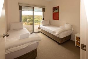 a bedroom with two beds and a sliding glass door at River Vista at Aruma in Walker Flat