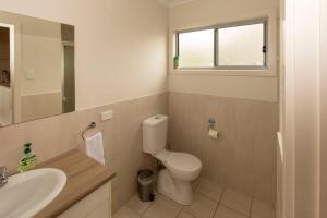 a bathroom with a toilet and a sink and a mirror at River Vista at Aruma in Walker Flat +23 photos