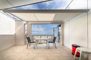a patio with a table and chairs and a view of the ocean at Le Rêve 210 in La Tranche-sur-Mer