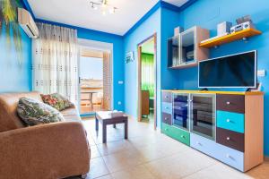 a blue living room with a couch and a tv at Neptuno in Oropesa del Mar
