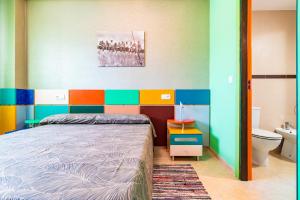 a bedroom with a bed and a colorful wall at Neptuno in Oropesa del Mar