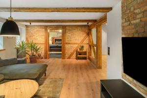a living room with a couch and a brick wall at Altes Höhlenführerhaus in Rübeland