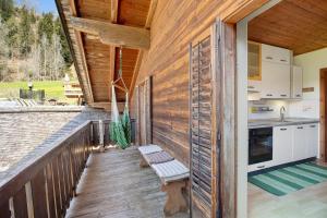 a wooden deck with a bench and a kitchen at Pitschlhof Apt Lärche in Aldino