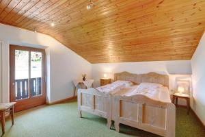 a bedroom with a large bed with a wooden ceiling at Pitschlhof Apt Lärche in Aldino