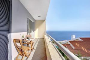 a balcony with a table and a view of the ocean at Apartamento Fénix Garajau in Caniço