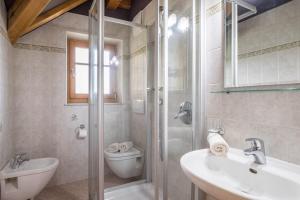 a bathroom with a shower and a toilet and a sink at Oberplunerhof - Fewo Gitschberg in Chienes +37 photos