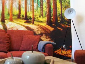 a living room with a painting of a forest at Ferienwohnung Niggemann in Bestwig