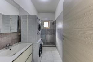 a bathroom with a sink and a washing machine at Messapica Rooms in Ugento +10 photos