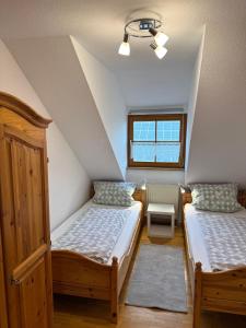 a bedroom with two beds and a window at Ferienhof Hanssler in Wilhelmsdorf