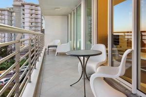 a balcony with white chairs and a table and some windows at Dfm Happy Days A - Funchal in Funchal
