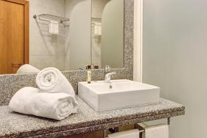 a bathroom with a white sink and a mirror at Dfm Happy Days A - Funchal in Funchal +6 photos