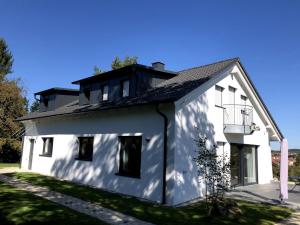 a white house with a black roof at Schöne Relaxunterkunft-barrierefrei in Mössingen