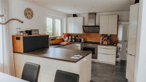 a kitchen with white cabinets and a counter top at Schöne Relaxunterkunft-barrierefrei in Mössingen +24 photos