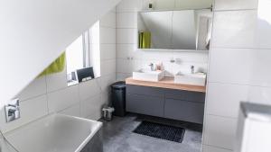 a bathroom with two sinks and a mirror at Schöne Relaxunterkunft-barrierefrei in Mössingen