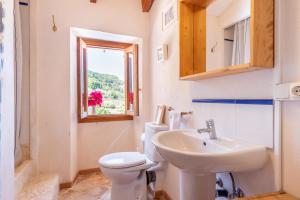 a bathroom with a sink and a toilet and a window at Little Paradise in Banyalbufar in Banyalbufar