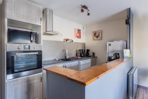 a kitchen with stainless steel appliances and a wooden counter top at Gîte À L'aube - 3 chambres in Saint-Aignan +16 photos