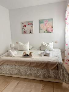 two cats sitting on a bed in a bedroom at Ático Garajonay in Cabo Blanco