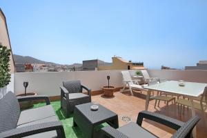 a patio with chairs and tables on a roof at Ático Garajonay in Cabo Blanco