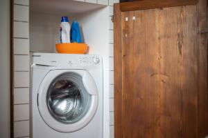 a washing machine in a bathroom with a wooden door at Loft Orsini - Pitigliano in Pitigliano