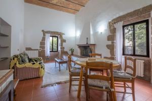 a living room with a table and chairs and a fireplace at Loft Orsini - Pitigliano in Pitigliano