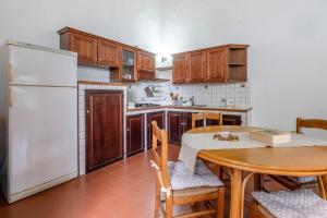 a kitchen with a table and a white refrigerator at Loft Orsini - Pitigliano in Pitigliano +19 photos