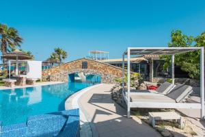 a pool at a resort with chairs and a bed at Mirage Arillas Villa Apartment in Arillas