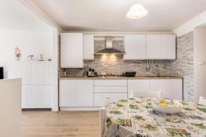 a kitchen with white cabinets and a table with a bowl on it at Appartamento Edik in Folgaria