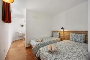 a bedroom with two beds with towels on them at Apartment Amado - Carrapateira in Carrapateira