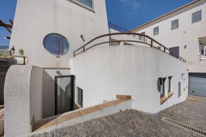 a white house with a staircase and a building at Apartment Amado - Carrapateira in Carrapateira