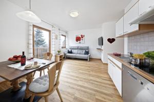 a kitchen and living room with a table and chairs at Langeshof Fewo Löwenzahn in Caines +16 photos