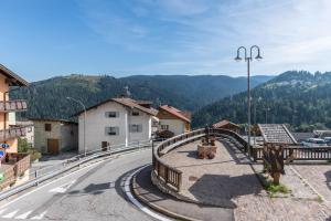 a bridge over a road with a mountain in the background at Appartamento Edik in Folgaria