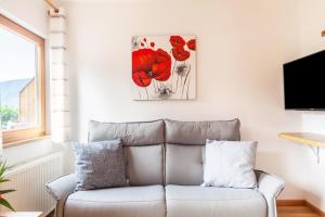 a living room with a couch and a painting on the wall at Langeshof Fewo Löwenzahn in Caines
