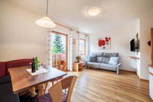a living room with a table and a couch at Langeshof Fewo Löwenzahn in Caines