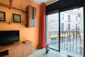 a living room with a tv and a large window at Apartament Yaco 2 in Lloret de Mar