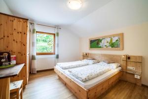 a bedroom with a bed and a desk and a window at Langeshof Fewo Löwenzahn in Caines