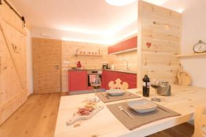 a kitchen with wooden walls and a table with wine glasses at Ferienwohnung Wold Wieserhof in Aldino +21 photos