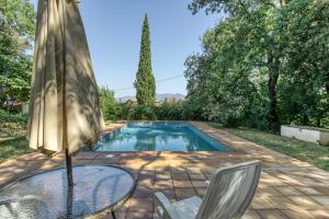 a pool with a table and chairs and an umbrella at El Revolt de Martís in Esponellá