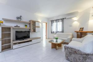 a living room with a couch and a tv at Villa Rosa in Benissa