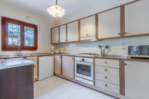 a kitchen with white appliances and wooden cabinets at Villa Rosa in Benissa