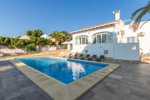 a villa with a swimming pool in front of a house at Villa Rosa in Benissa