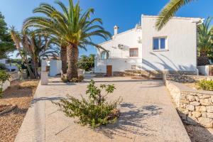 a white house with palm trees in front of it at Villa Rosa in Benissa