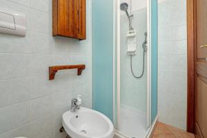 a bathroom with a shower with a toilet and a sink at New Villa Carmen in San Teodoro +14 photos