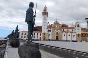 a statue of a man standing in front of a building at Tamaragua in Candelaria