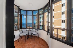 a room with windows and a table and chairs at Tamaragua in Candelaria