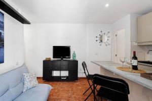 a living room with a couch and a kitchen with a counter at Tamaragua in Candelaria