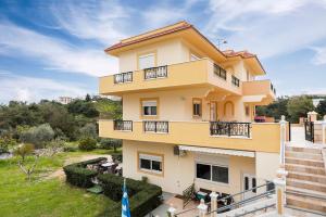 a large yellow building with balconies on it at Rafaela's House in Koskinou