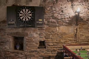 a dart board on a stone wall next to a table at El Pajariel I in Valdecañada