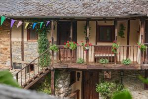 an old house with a balcony with flowers on it at El Pajariel I in Valdecañada