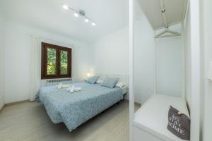 a white bedroom with a bed and a window at Sestel in Capdepera +22 photos