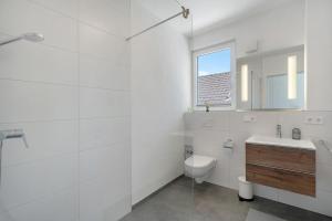 ein weißes Badezimmer mit Toilette und Waschbecken in der Unterkunft Katharinenbergblick in Endingen + 17 Fotos